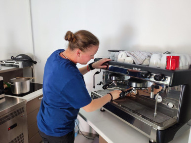 Sumero Savez beneficiary Nejra H. prepares coffee in the "Inspire Corner" cafeteria. She is currently undergoing occupational therapy in this cafeteria.